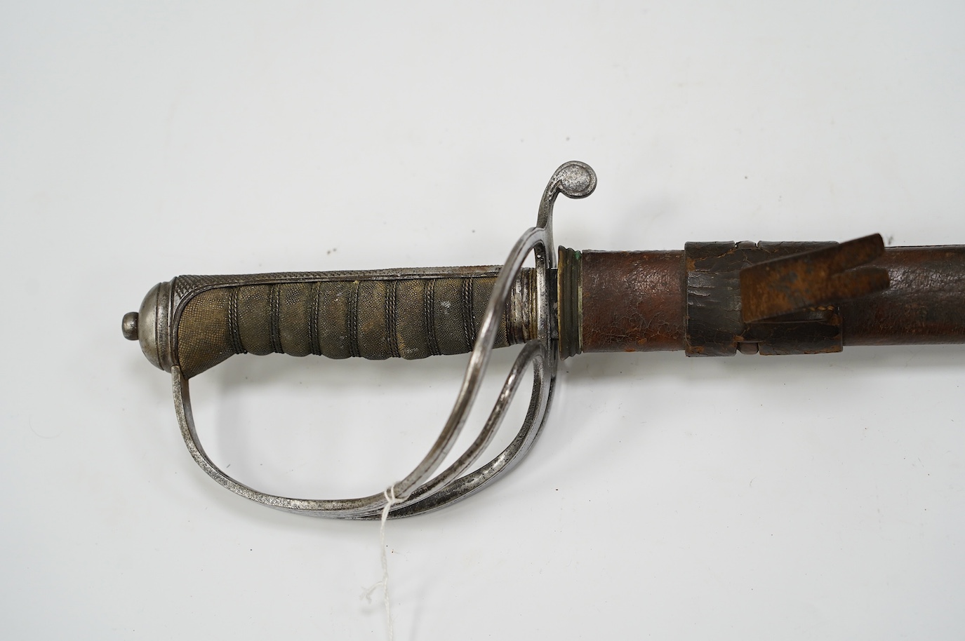 A George V Royal Artillery sword, regulation blade and hilt, in its leather scabbard, blade 90cm. Condition - poor, heavily pitted
